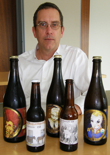 Pete Kennedy poses with the 750-ml bottles of beer from his client Jester King Craft Brewery as well as his own homebrewed beer.