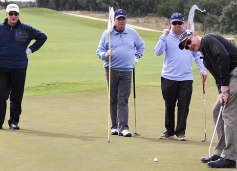 AT&T's Tom Horn, Dave Nichols, Joe Cosgrove look on as Mark Witcher sinks a putt