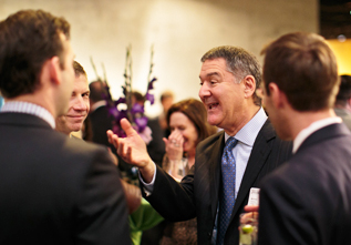 V&E partner Mike Saslaw, center, chats with guests at the firm’s client party